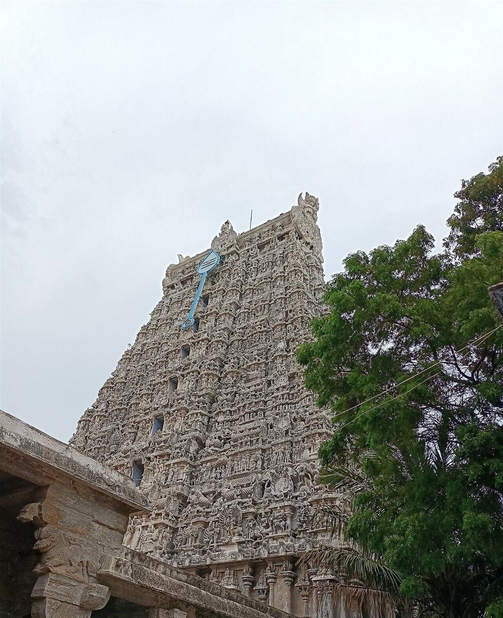The nine-tier Rajagopuram of Tiruchendur temple covered in stucco sculpture, with the vel emblem near its crown
